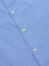 Close-up of the Blue End On End Cotton Garage Shirt. The light blue cotton fabric has white buttons. The shirt is on a flat surface.