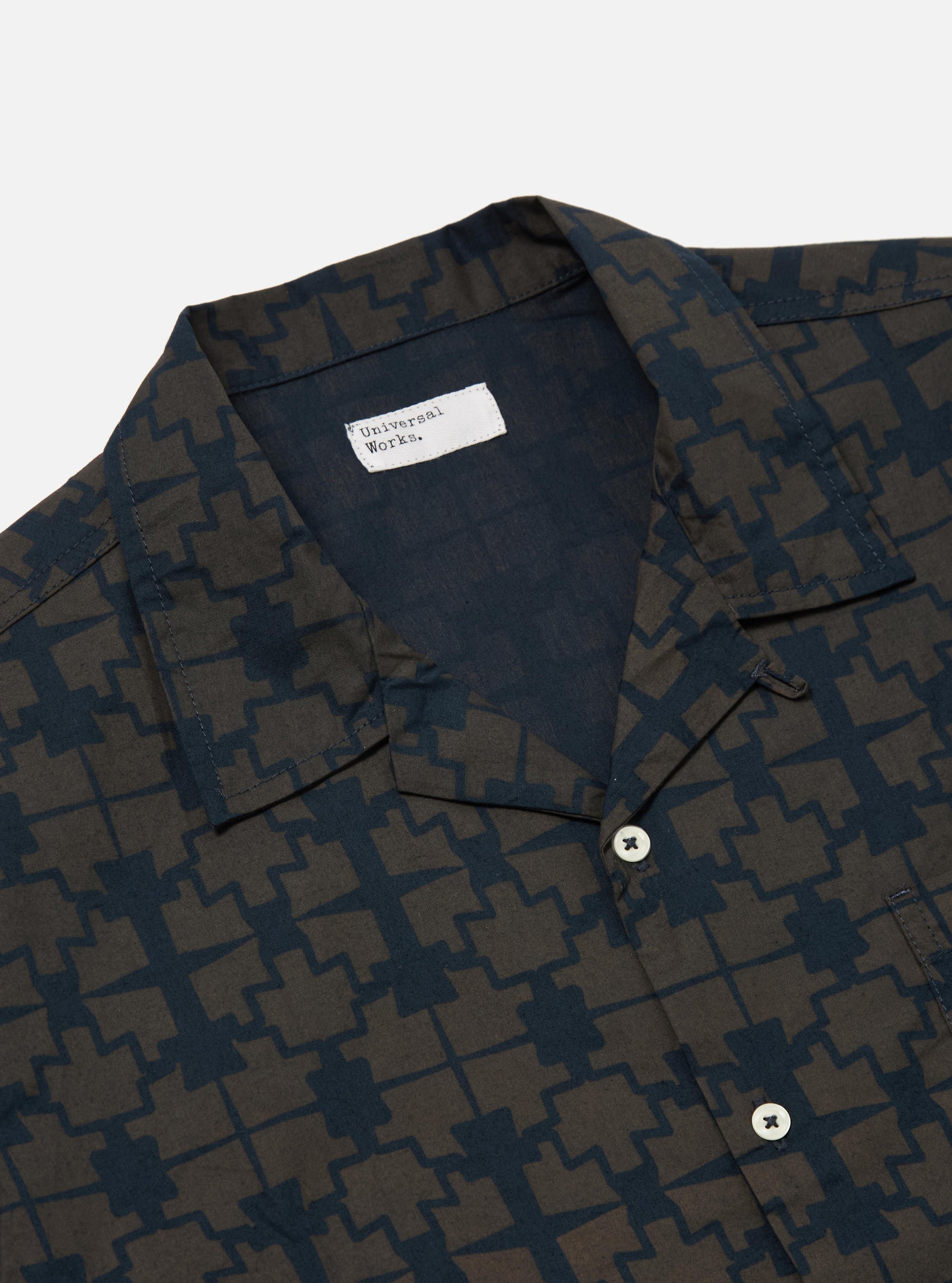 Close-up of the Navy Mitla Print Cotton Road Shirt on a white background. The shirt features a navy and brown geometric print, short sleeves, and a camp collar.