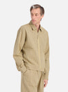 A model poses in a Yellow Japanese Seersucker Zip Uniform Jacket against a white background. The jacket is a light yellow with a subtle checkered pattern and a zip front.