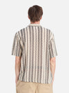 Back view of a man wearing a Charcoal Cotton Lattice Road Shirt. The shirt has a geometric pattern. Shot on a white background.