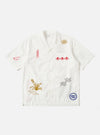The Ecru Embroidered Poplin Minari Shirt on a white background. The short sleeve shirt has red, gold, and black embroidery. The shirt is made of poplin.