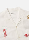 Close-up of the Ecru Embroidered Poplin Minari Shirt on a white background. The shirt features red and gold embroidery details.