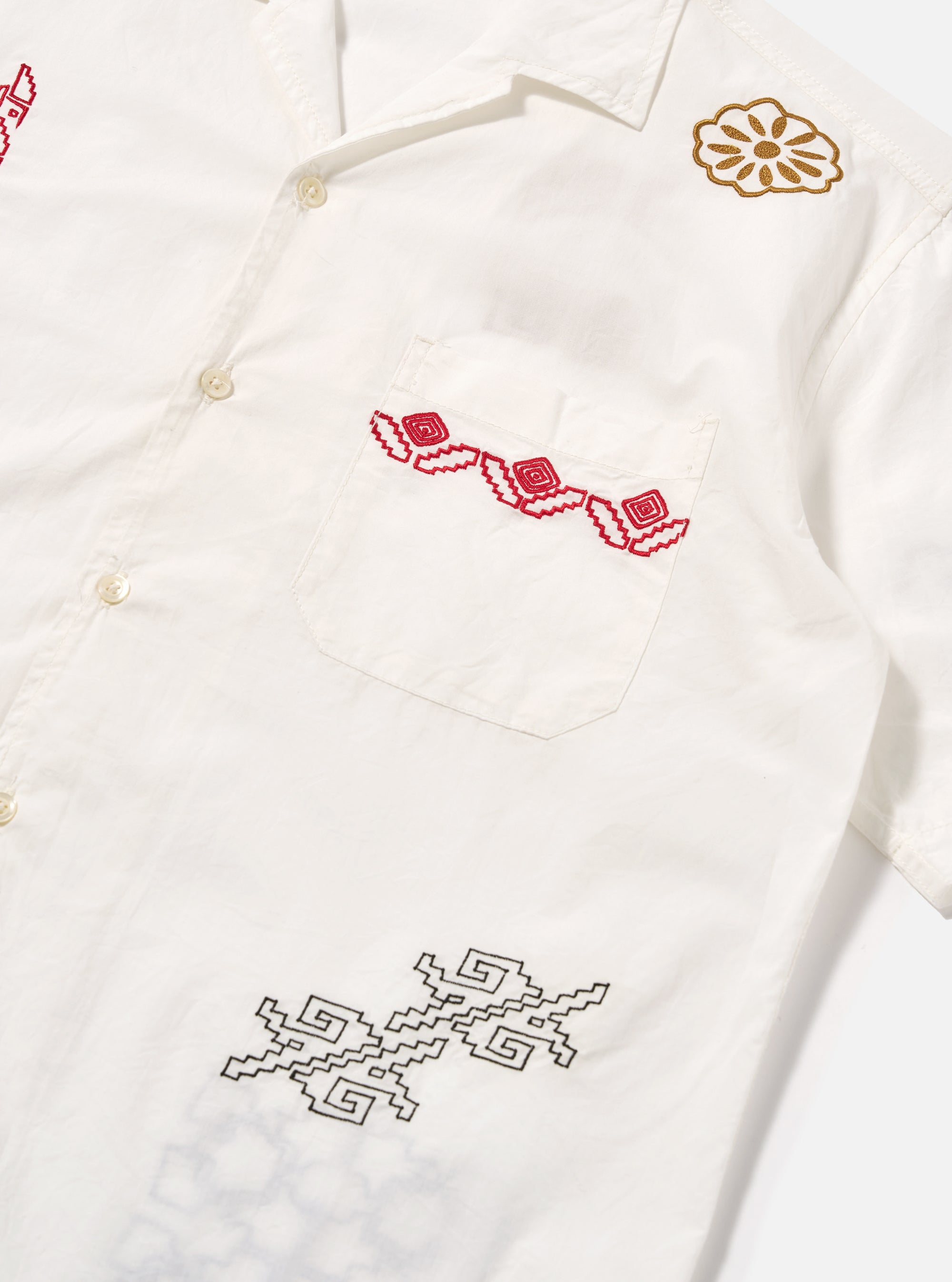 Close-up of the ecru poplin Minari shirt with red and gold embroidery on a white background. The shirt has a camp collar and a chest pocket.