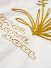 Close-up of the Ecru Embroidered Poplin Minari Shirt. Features gold embroidery on ecru poplin. The shirt is laid flat on a neutral surface.