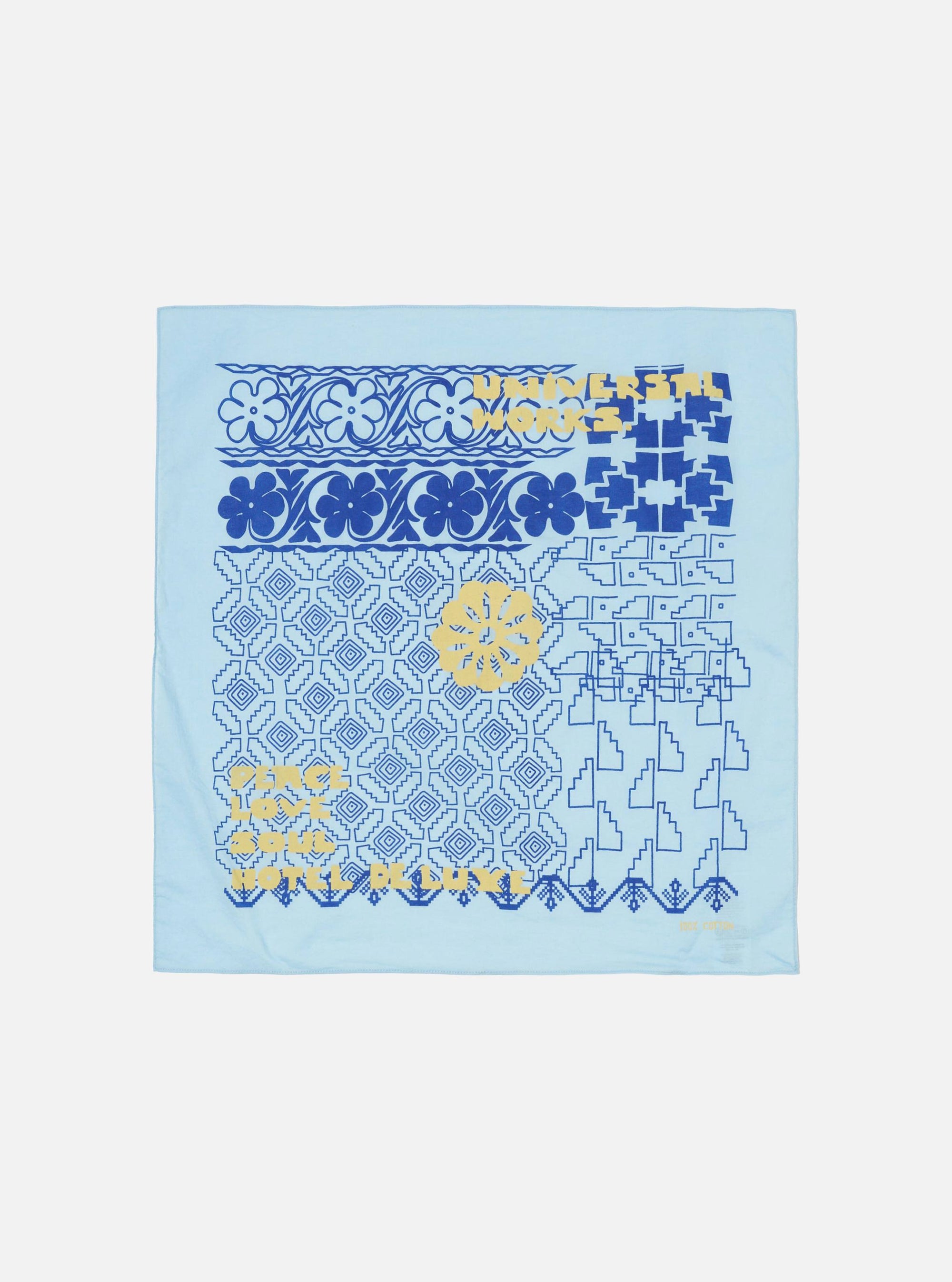 Flat lay of a Blue Cambric Kingsman Neckerchief on a white surface. The neckerchief has blue and yellow patterns.