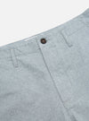 Close-up of the Indigo Reworked Jean Cloth Alva Short. Light blue denim texture with a brown button. Shot on a white background.