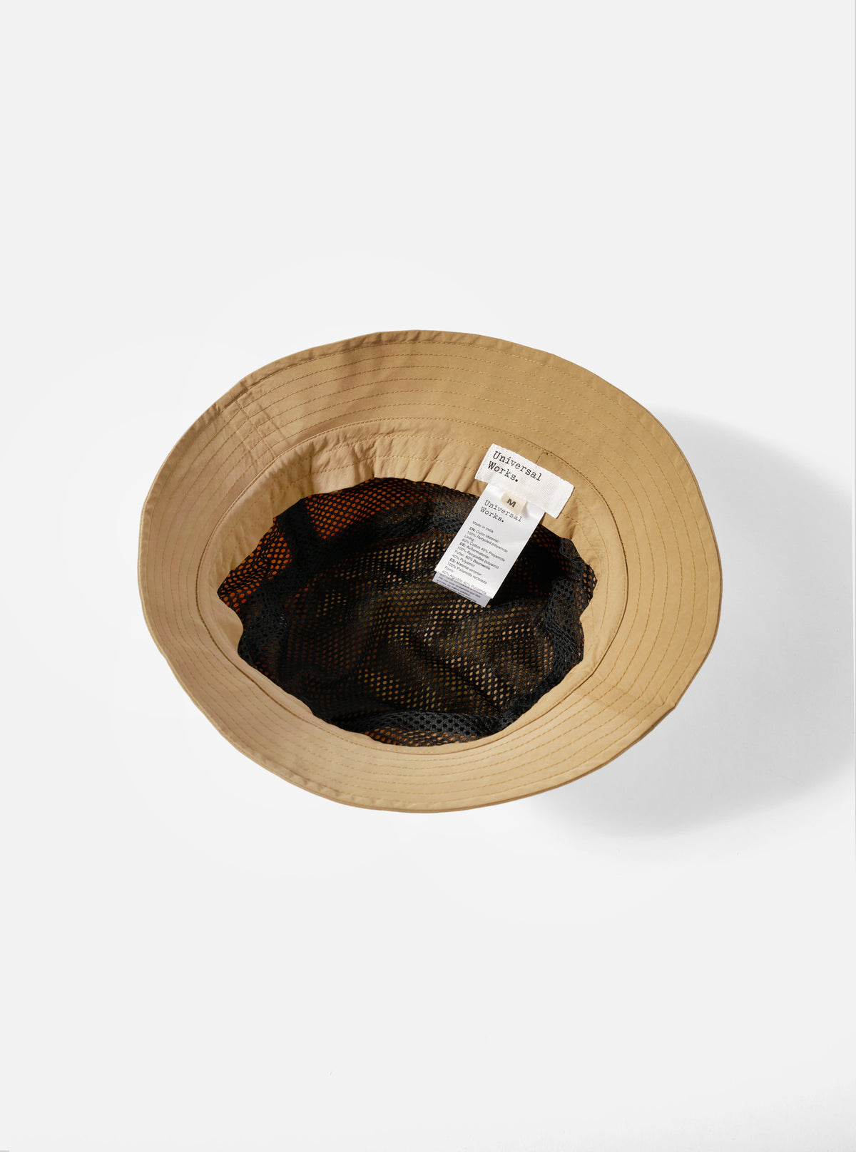 Inside view of the Dark Sand Peach Recycled Nylon Beach Hat on a white background. The hat has a black mesh lining and a fabric tag.
