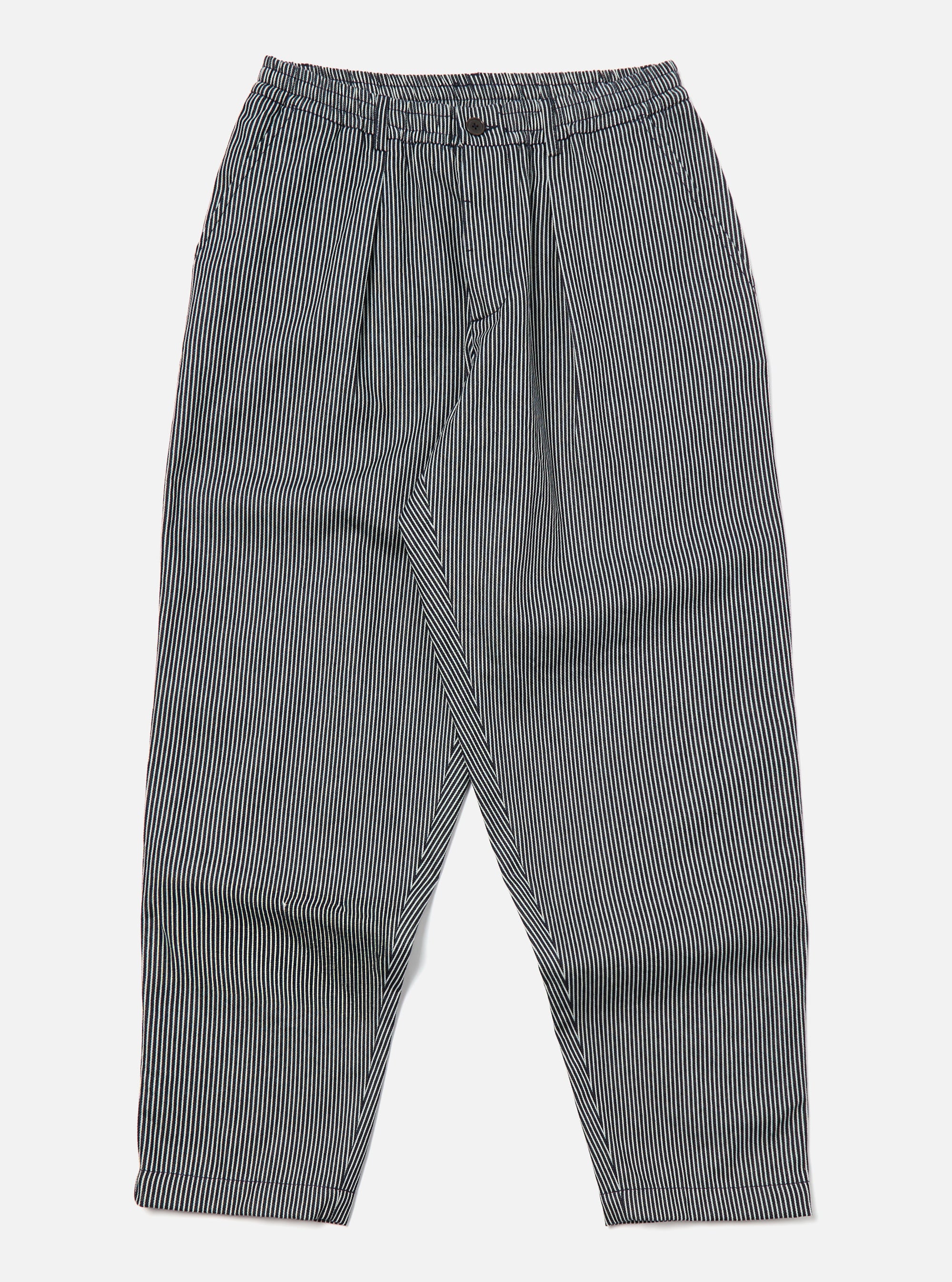 Studio shot of Indigo Hickory Stripe Denim Pleated Track Pant on a white background. The pants are striped with a relaxed fit.