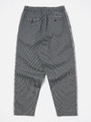 Back view of Indigo Hickory Stripe Denim Pleated Track Pant on a white surface. The pants have a relaxed fit and feature a striped pattern.