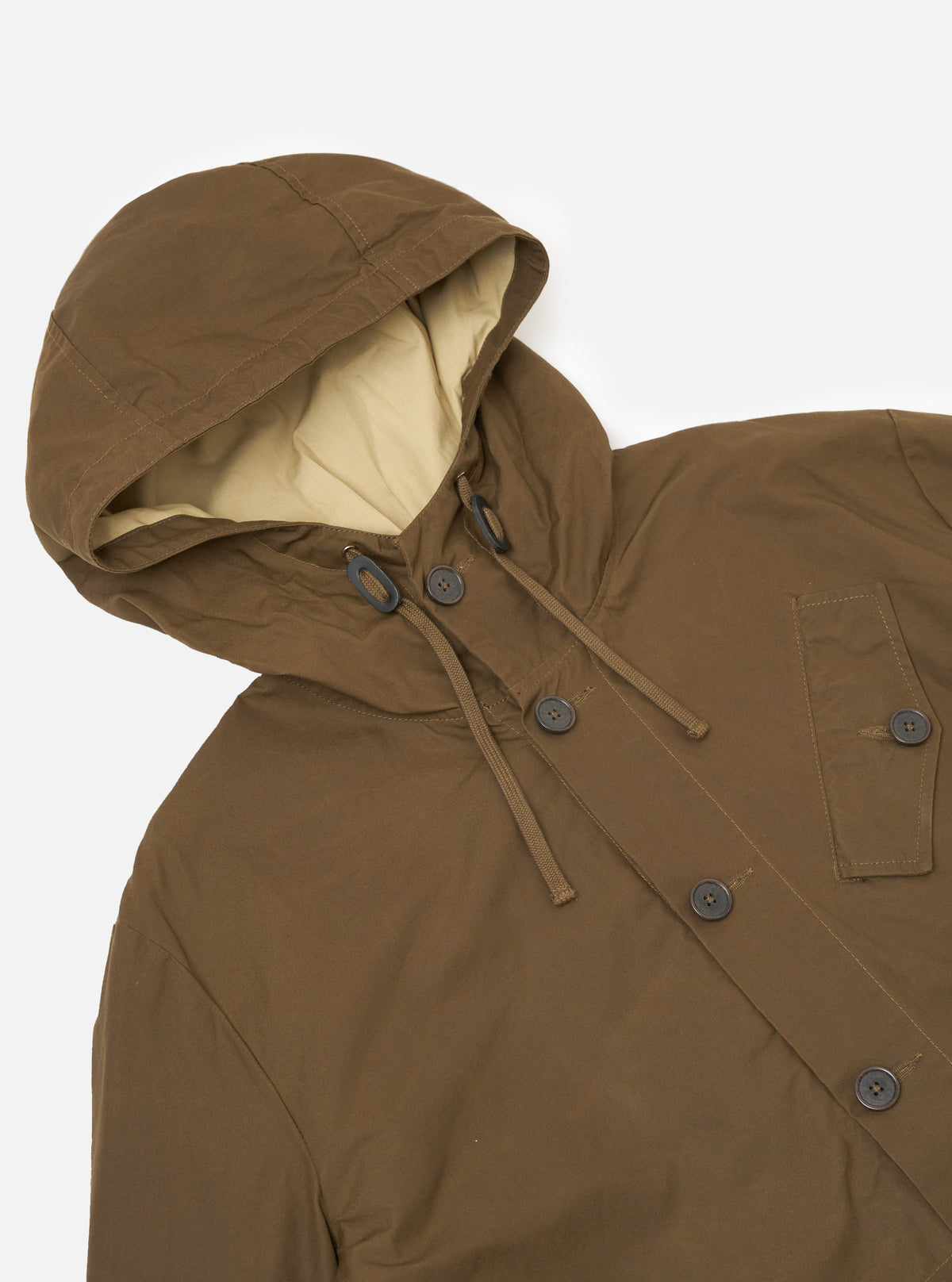 Close-up of the Brown British Wax Cotton Boston Parka on a white background. The parka features a lined hood, button closure, and a relaxed fit.