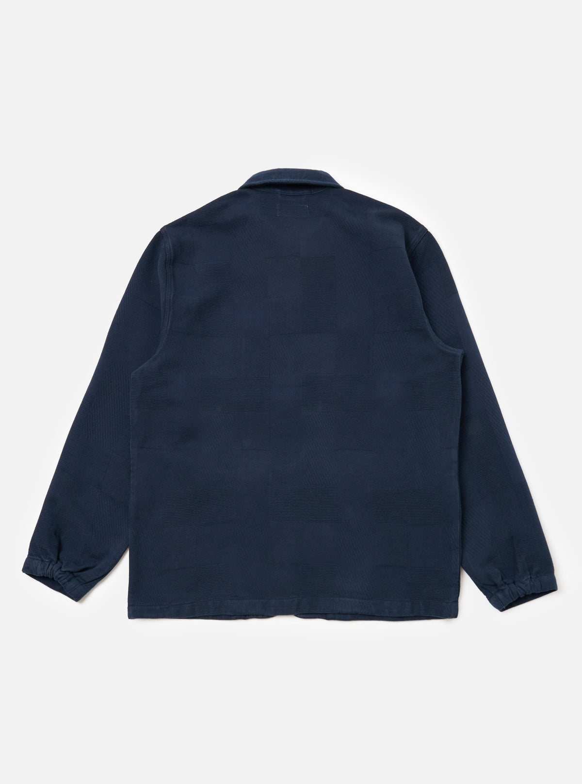 Back view of the Dark Navy Patchwork Weave Cotton Labour Jacket on a white background. The jacket features a subtle patchwork design and a classic collar.
