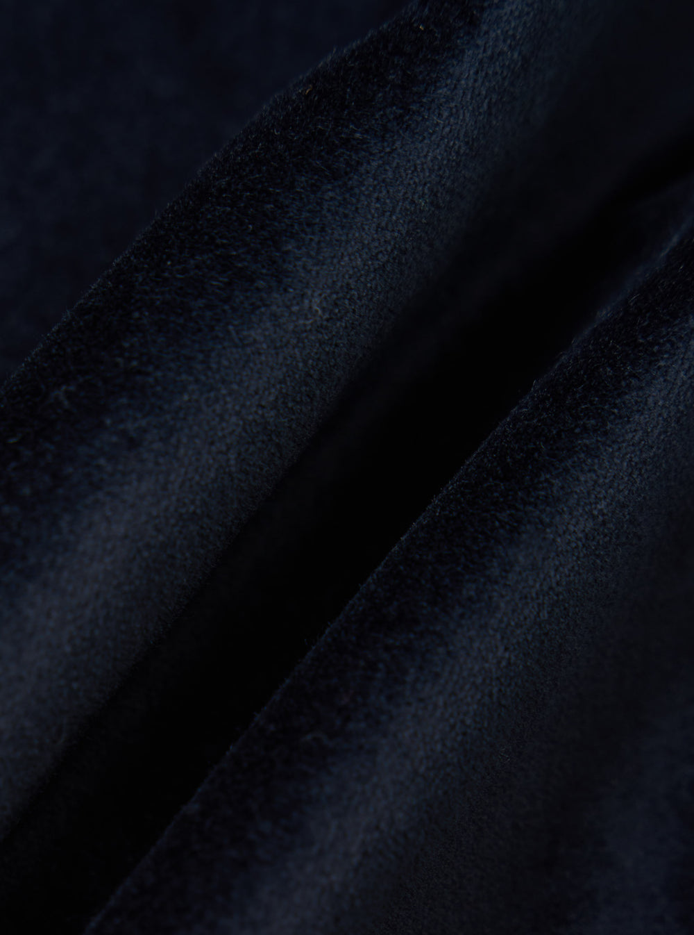 Close-up of the Navy Velveteen Manor Jacket fabric. The soft, plush texture of the navy velvet is highlighted against a simple background.