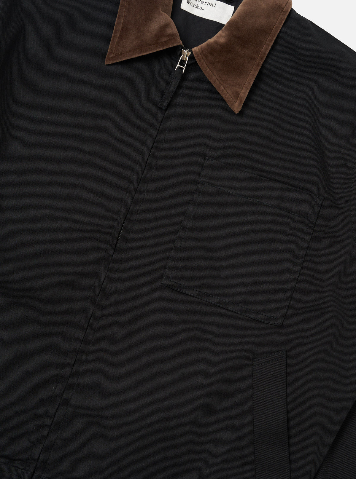 Close-up of the Black Works Twill Rose Bowl Jacket. Features a black twill body, brown corduroy collar, and zip closure. Shot on a plain background.