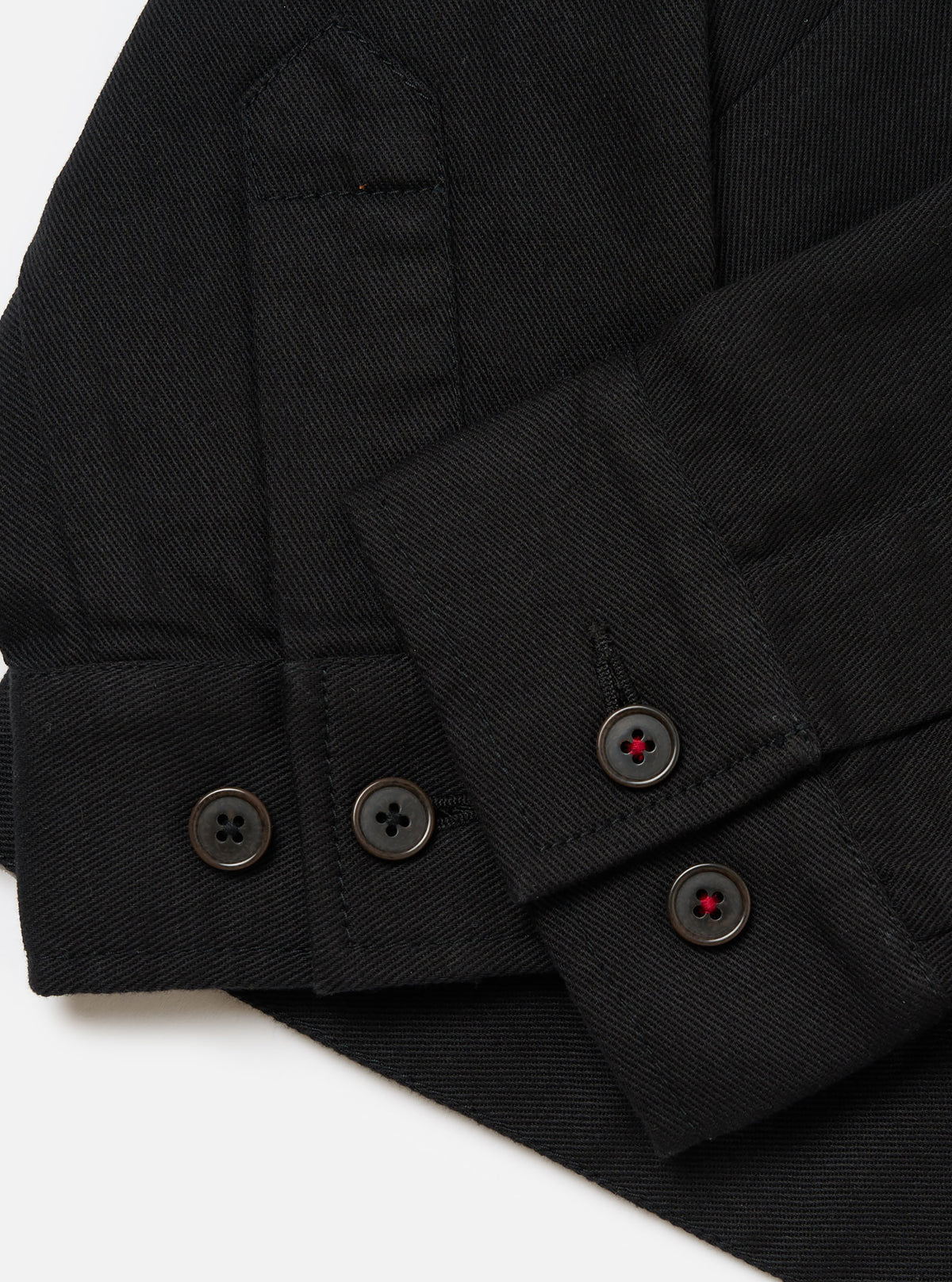 Close-up of the Black Works Twill Rose Bowl Jacket showing the black twill material, buttoned cuffs, and pocket detail on a white background.