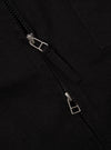 Close-up of the Black Works Twill Rose Bowl Jacket. The black twill fabric is visible, along with the jacket's zipper. The background is a plain, dark surface.