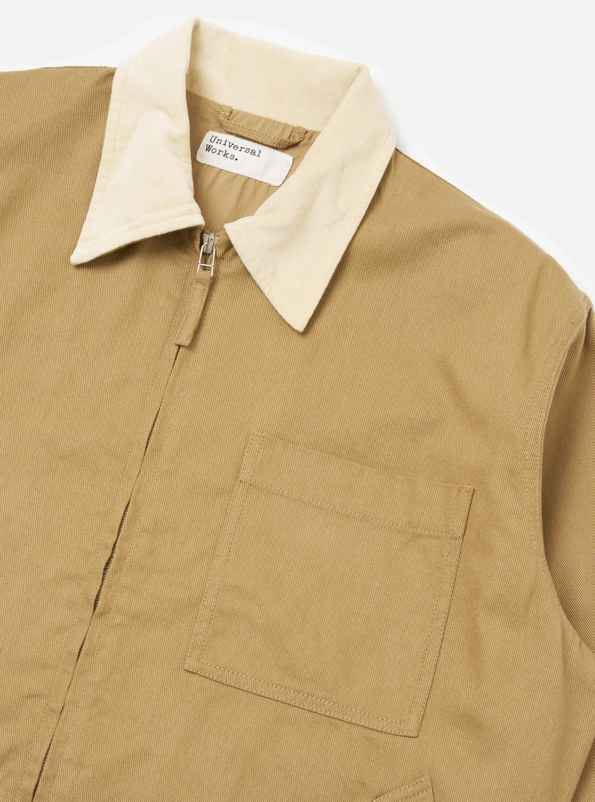 Close-up of the Khaki Works Twill Rose Bowl Jacket on a white background. The jacket is khaki with a cream-colored collar and a front zipper. A pocket is visible on the left side.