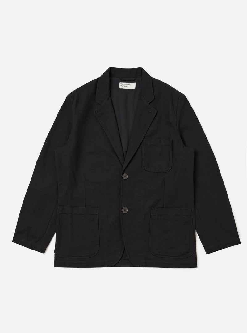 The Black Organic Canvas Two Button Jacket is laid flat on a white background. The jacket is a dark black color and has two pockets on either side.