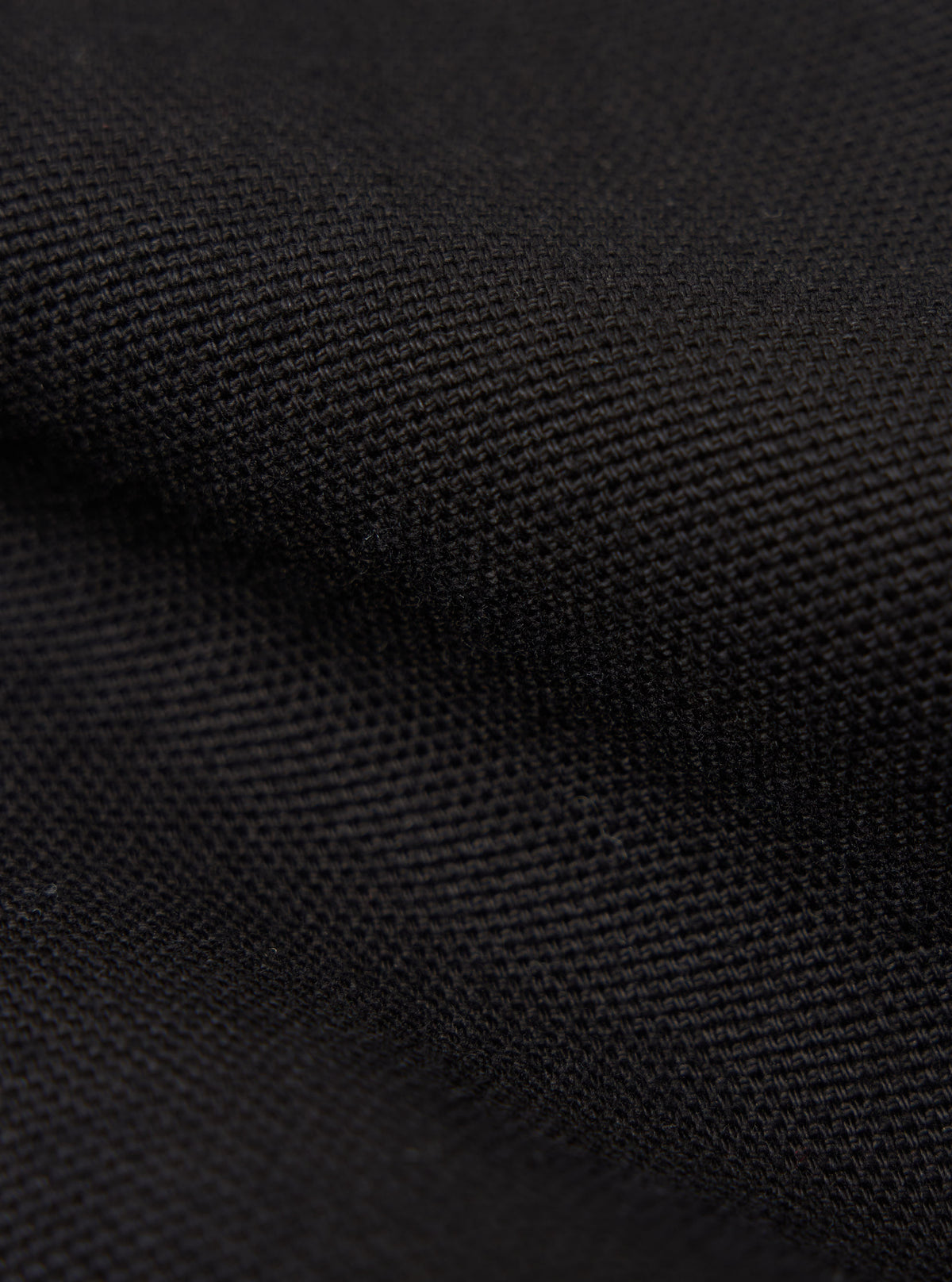 Close-up of the Black Organic Canvas Two Button Jacket fabric. The dark canvas shows a detailed weave pattern.