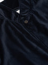 Close-up of the navy velveteen two button jacket. The soft, luxurious fabric is highlighted in the studio lighting. The jacket features a classic, tailored fit.