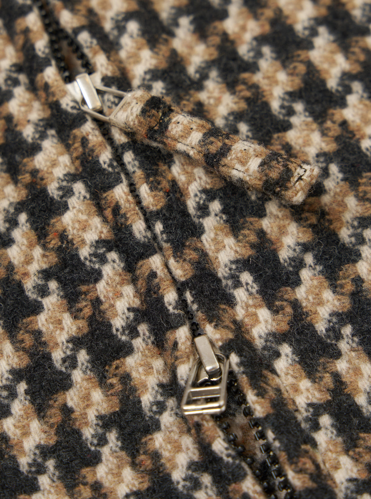 Close-up of the Sand Cortina Tweed Windcheater, showcasing the tweed material and zipper. The tweed is a mix of sand, brown, and black. 