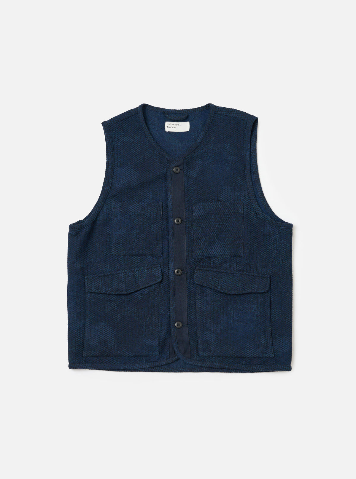 The Black/Indigo Denim Camo 4 Pocket Gilet is displayed on a white background. The gilet is indigo with a subtle camo pattern, featuring four pockets and a button-up front.