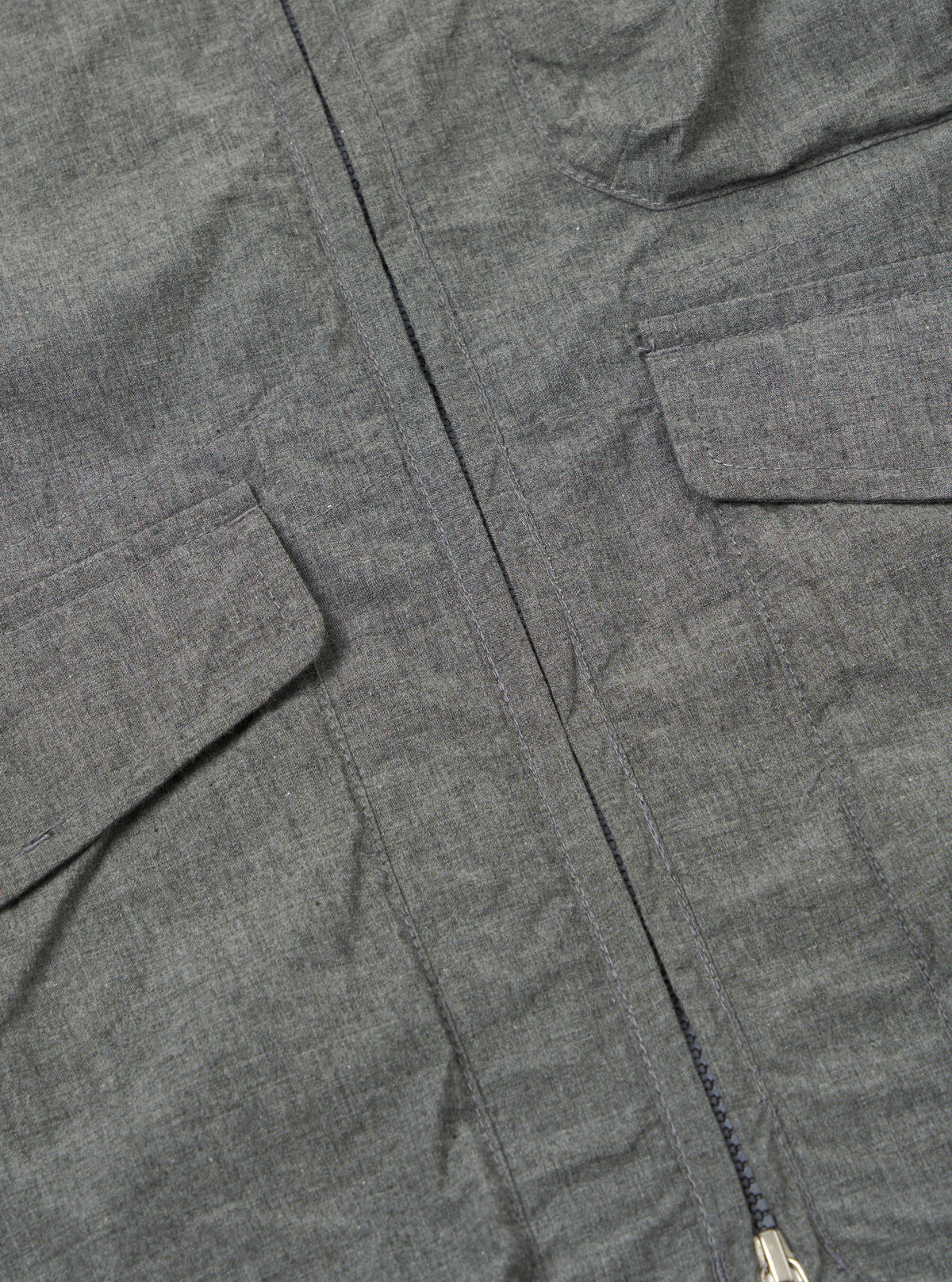 Close-up of the Charcoal Organic Chambray Parachute Liner Gilet, showcasing the fabric texture, pockets, and zipper detail on a flat surface.