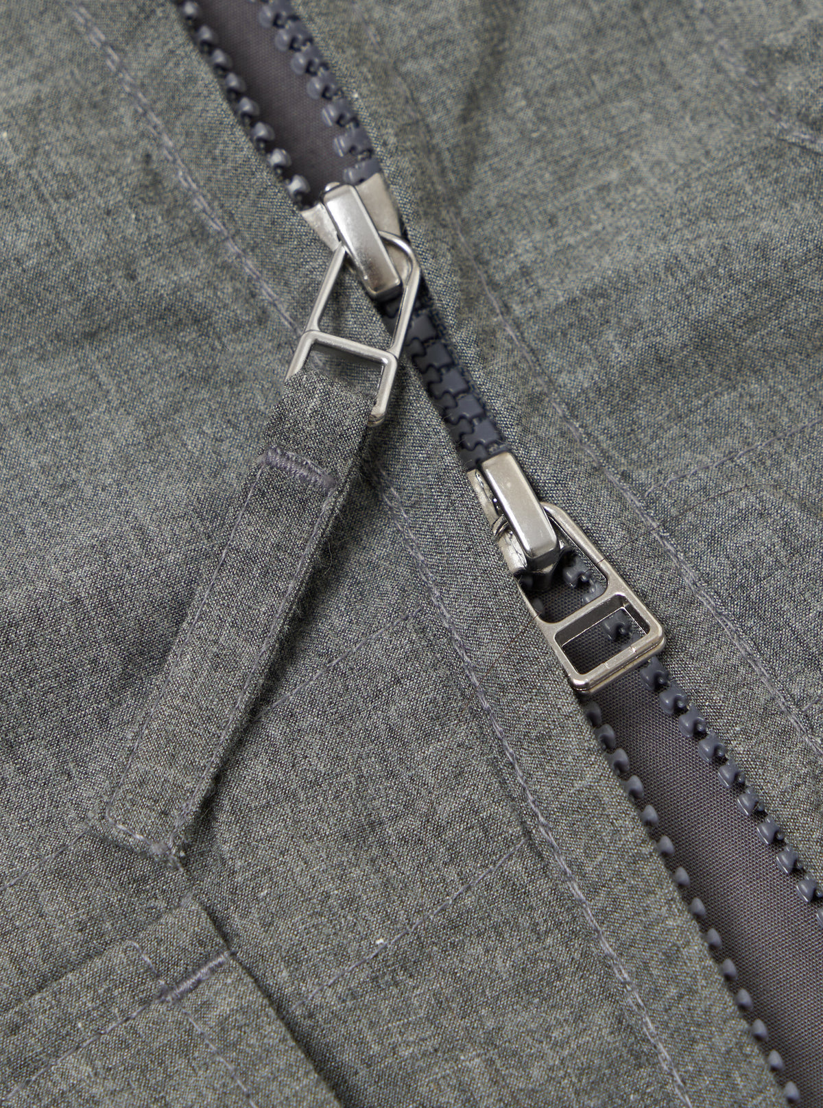 Close-up of the Charcoal Organic Chambray Parachute Liner Gilet, showcasing the organic chambray material and zipper detailing. The image highlights the texture and construction.