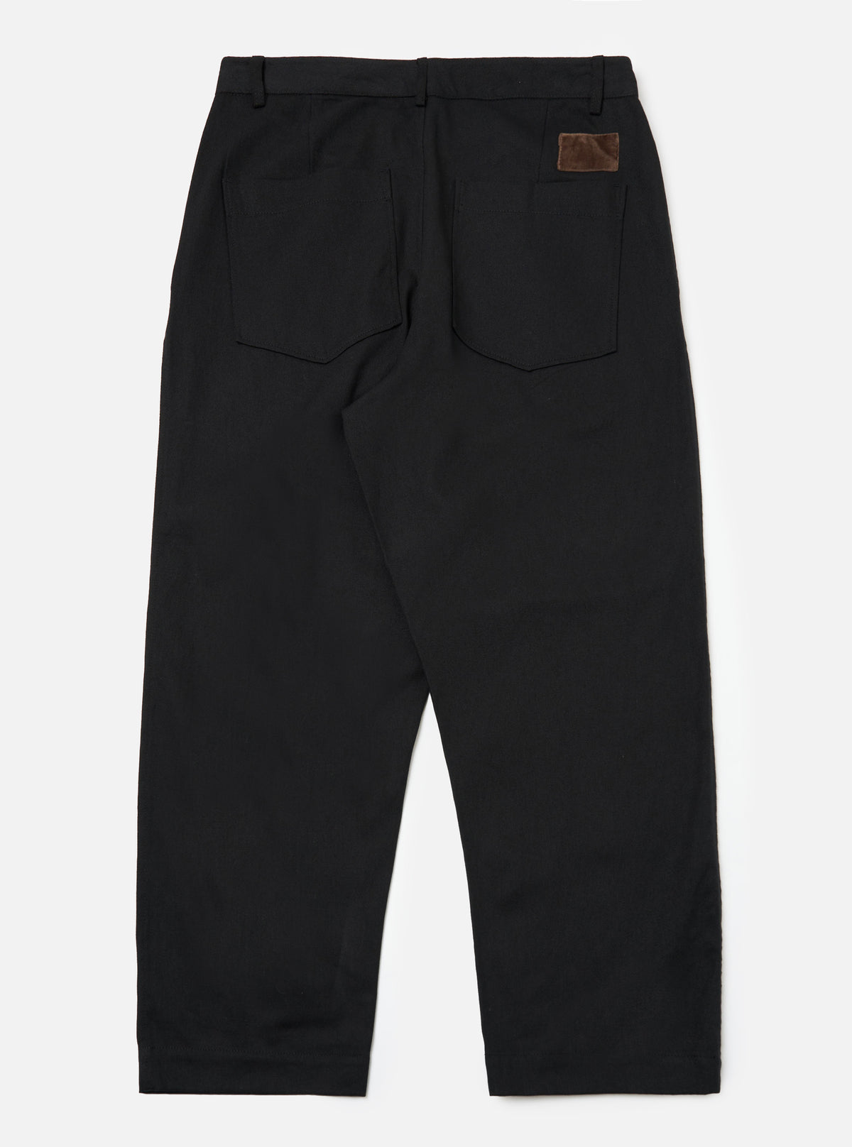 Back view of Black Works Twill Duke Pant on a white background. The black twill pants have a relaxed fit and feature a brown leather patch on the back pocket.