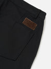 Close-up of the Black Works Twill Duke Pant, showcasing the black twill fabric, pocket detail, and brown patch on a white background.