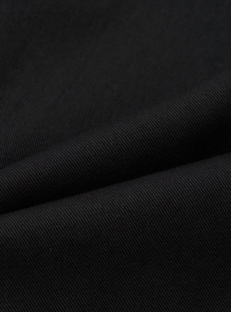 Close-up of the Black Works Twill Duke Pant, showcasing the dark twill fabric and texture. The pants are draped to highlight the material's quality.
