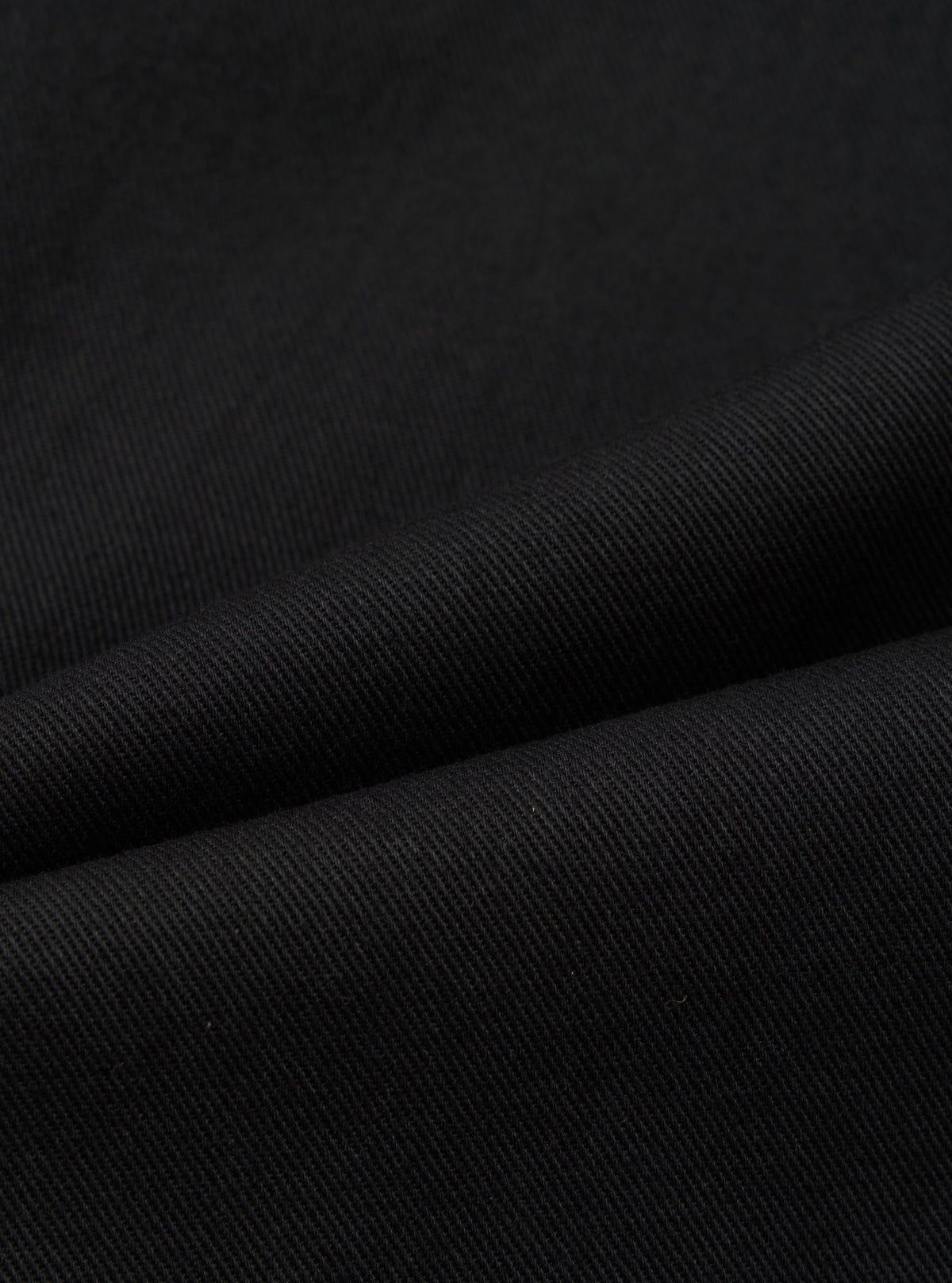 Close-up of the Black Works Twill Duke Pant, showcasing the dark twill fabric and texture. The pants are draped to highlight the material's quality.