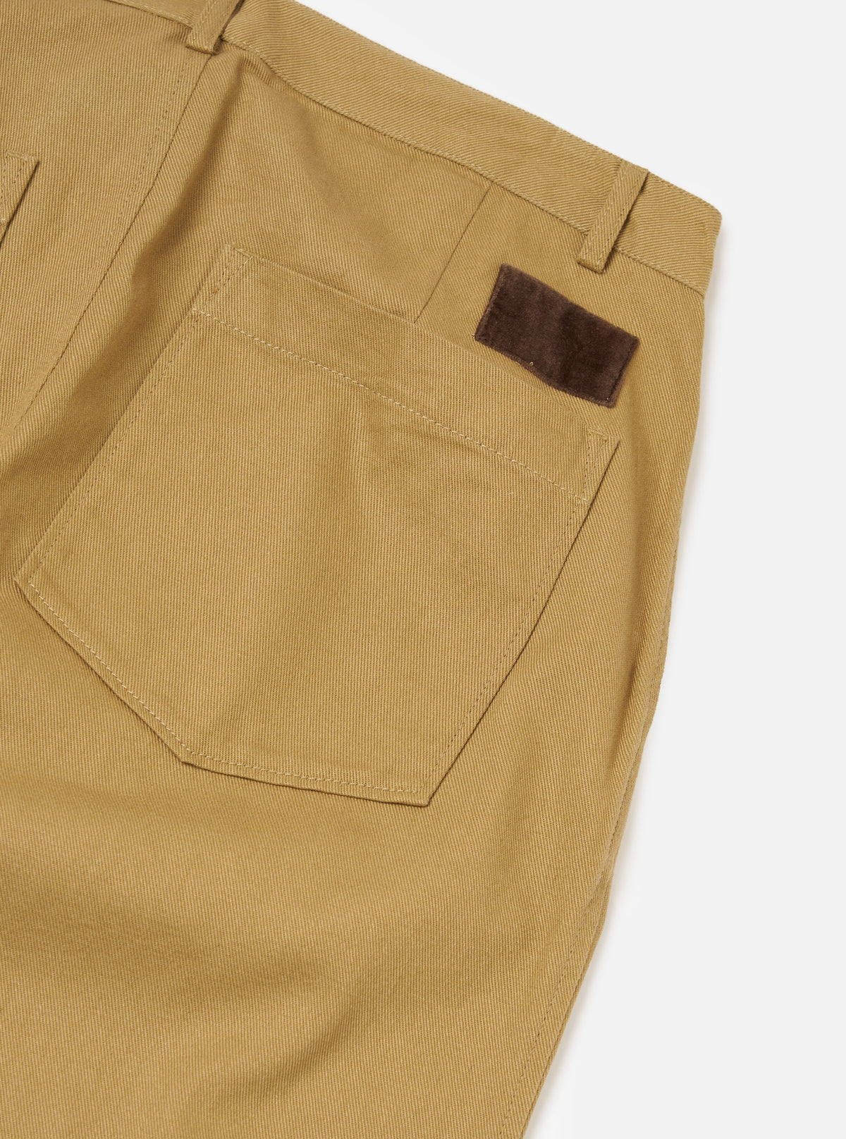 Close-up of the Khaki Works Twill Duke Pant in khaki twill on a white background. Shows back pocket and brown suede tag.