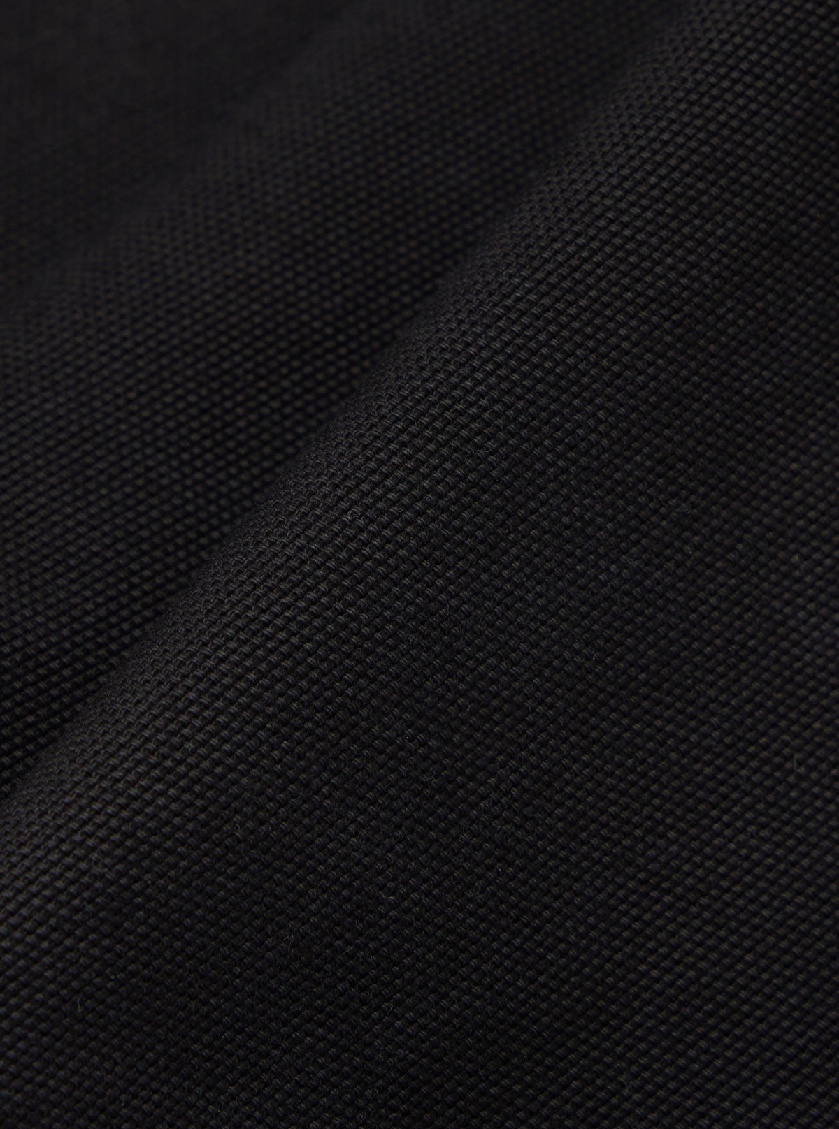 Close-up of the Black Organic Canvas Dutch Pant fabric. The durable, textured material is displayed on a plain background.