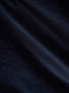 Close-up of the Navy Velveteen Military Chino fabric. The soft, dark blue material is draped to show its texture and quality. The background is a simple, neutral surface.