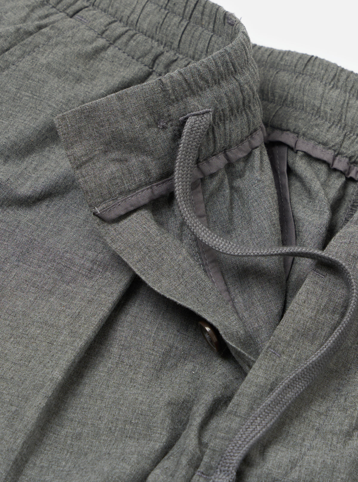 Close-up of the Charcoal Organic Chambray Oxford Pant, showcasing the organic chambray material, elastic waistband with drawstring, and button closure on a white background.