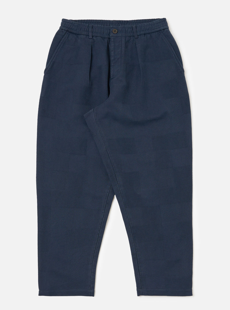 Dark navy patchwork weave cotton pleated track pant on a white background. The pants have a relaxed fit and a subtle textured pattern.