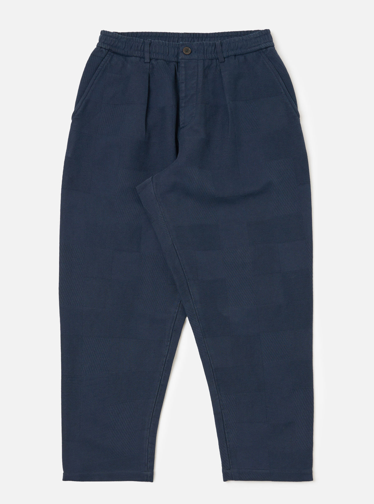 Dark navy patchwork weave cotton pleated track pant on a white background. The pants have a relaxed fit and a subtle textured pattern.