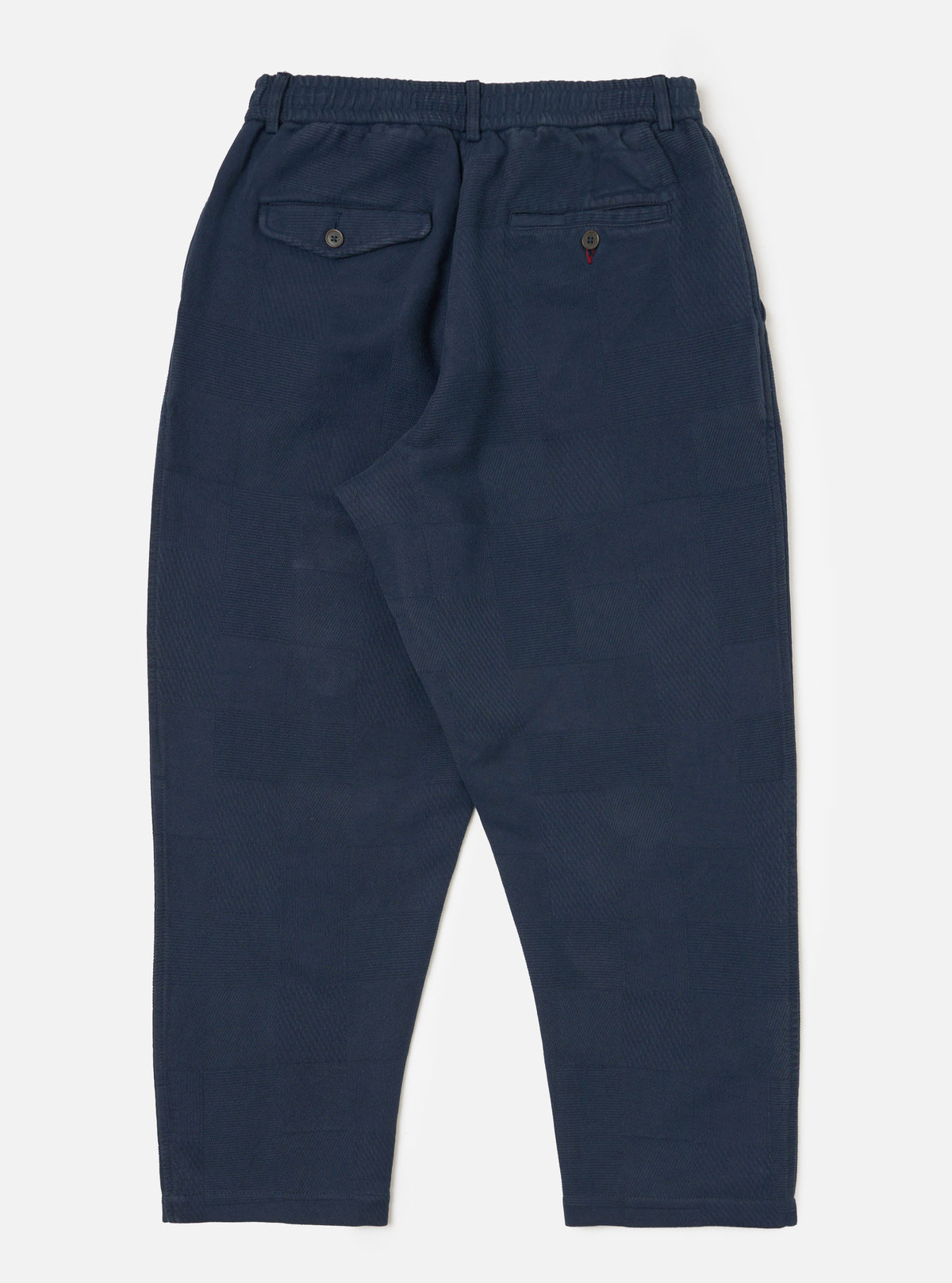 Dark navy patchwork weave cotton pleated track pant laid flat on a white background. The pants have an elastic waistband and two back pockets.