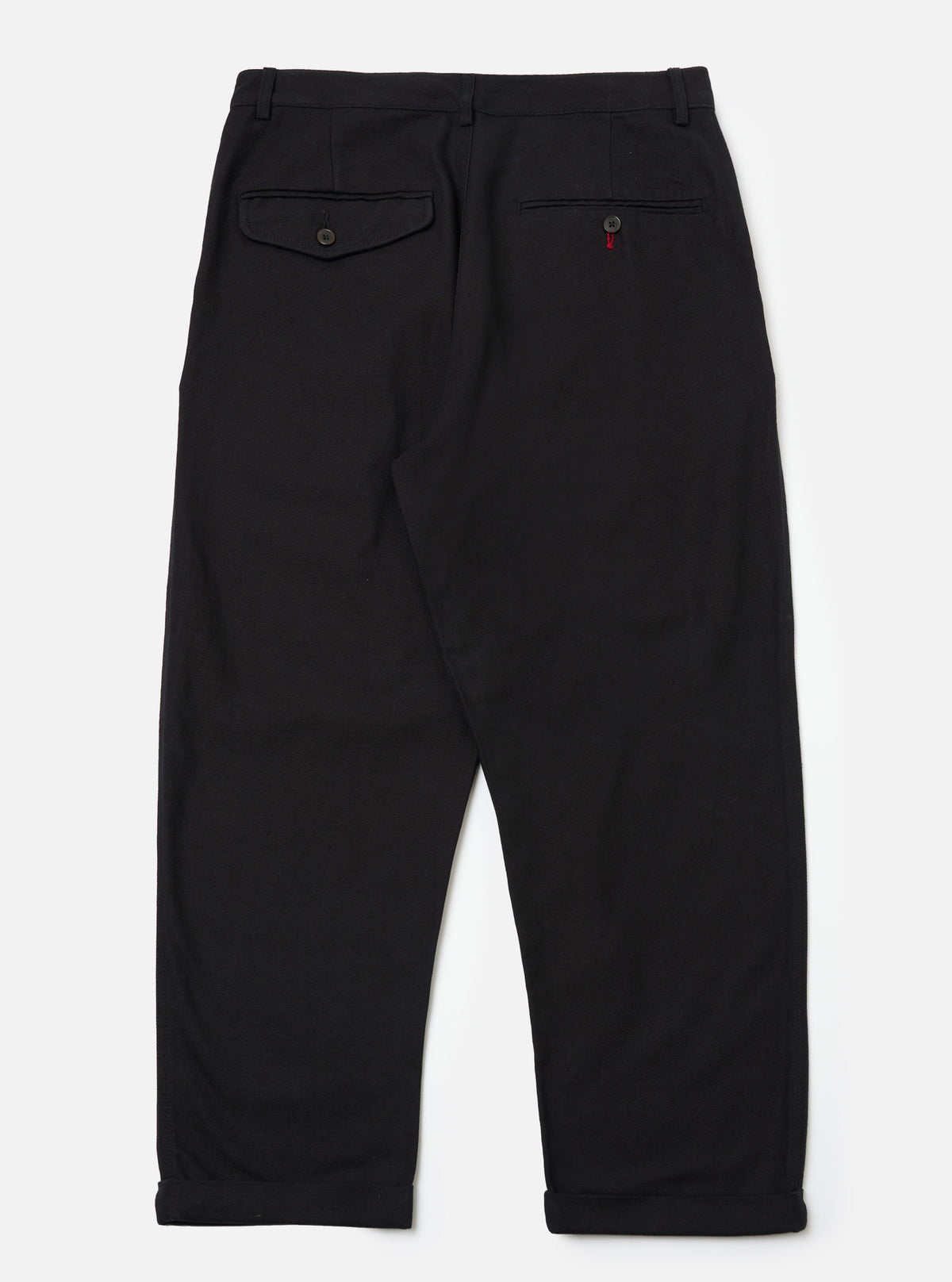 The Black Organic Canvas Super Chino laid flat on a white background. The chinos are black canvas with a relaxed fit and cuffed hems.