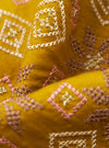 Close-up of the Mustard Embroidery Cotton Satin Embroidery Scarf. The mustard fabric features pink and white geometric embroidery. The scarf is draped on a dark background.