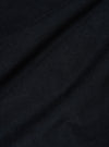 Close-up of the Black Organic Fine Cord Fatigue Shirt fabric. The fine cord texture is visible in the black material, draped on a flat surface.