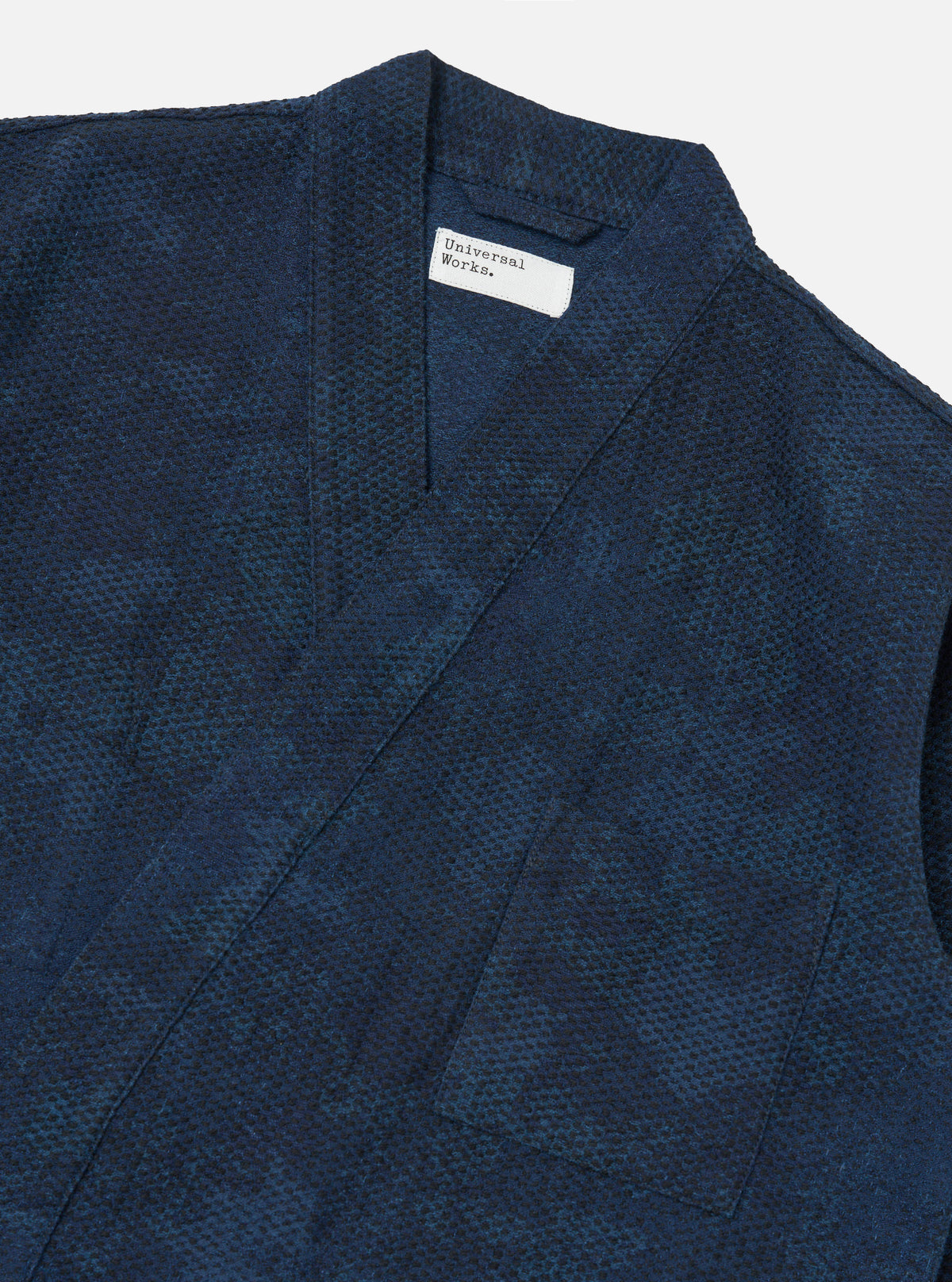 Close-up of the Black/Indigo Denim Camo Kyoto Work Jacket on a white background. The jacket features a unique camo pattern in black and indigo denim, showcasing its workwear-inspired design.