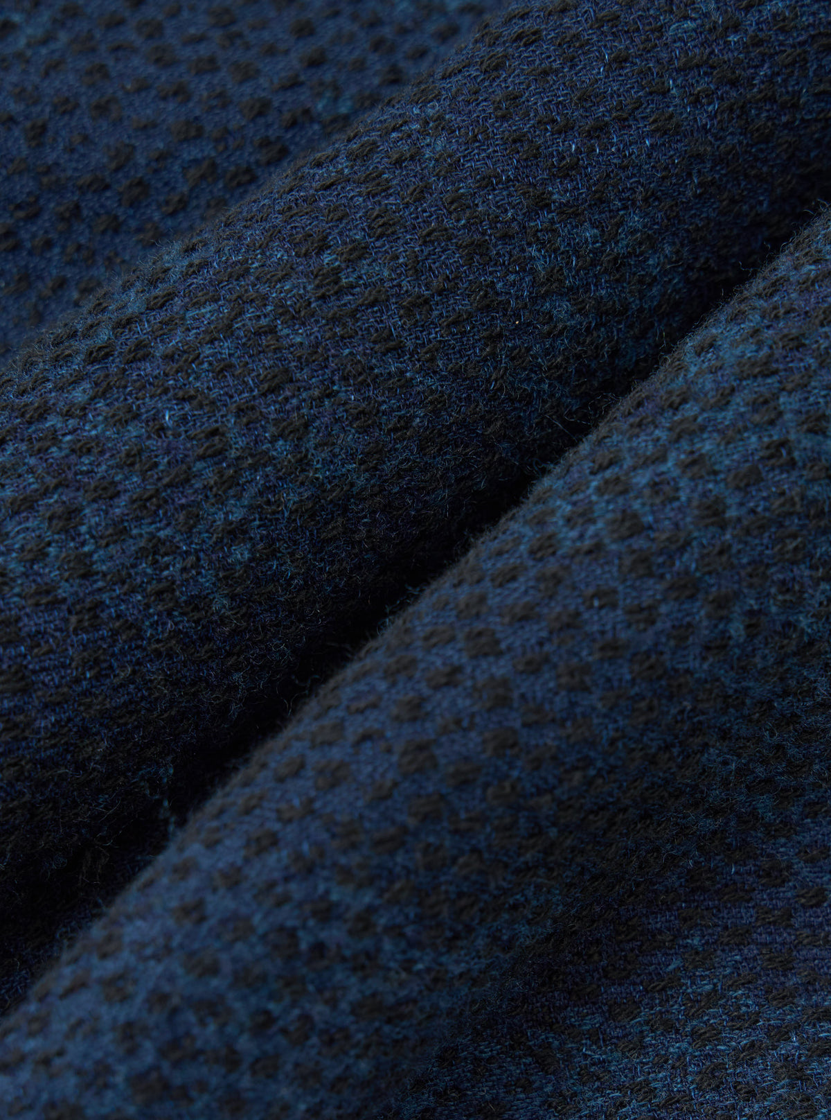 Close-up of the Black/Indigo Denim Camo Kyoto Work Jacket fabric. The material is a textured denim with a subtle camo pattern in black and indigo. 