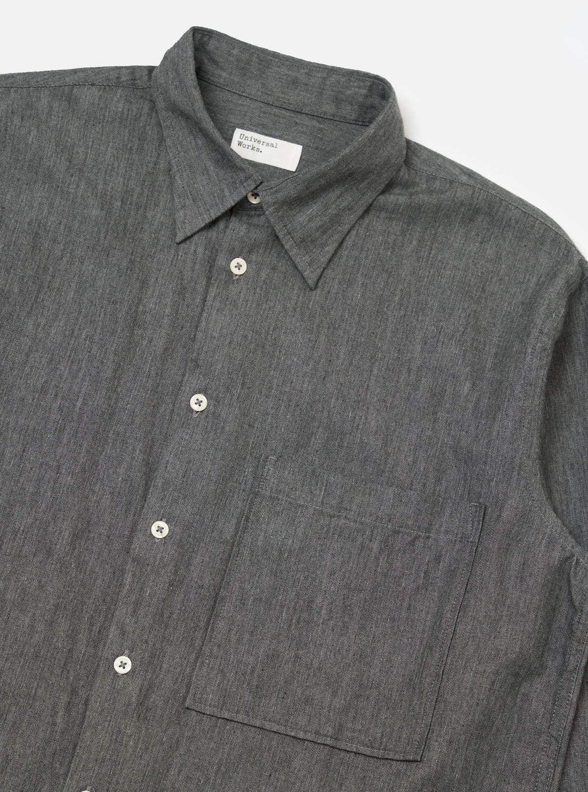 Close-up of the Charcoal Brushed Organic Cotton Square Pocket Shirt on a white background. The shirt is buttoned with a square pocket.