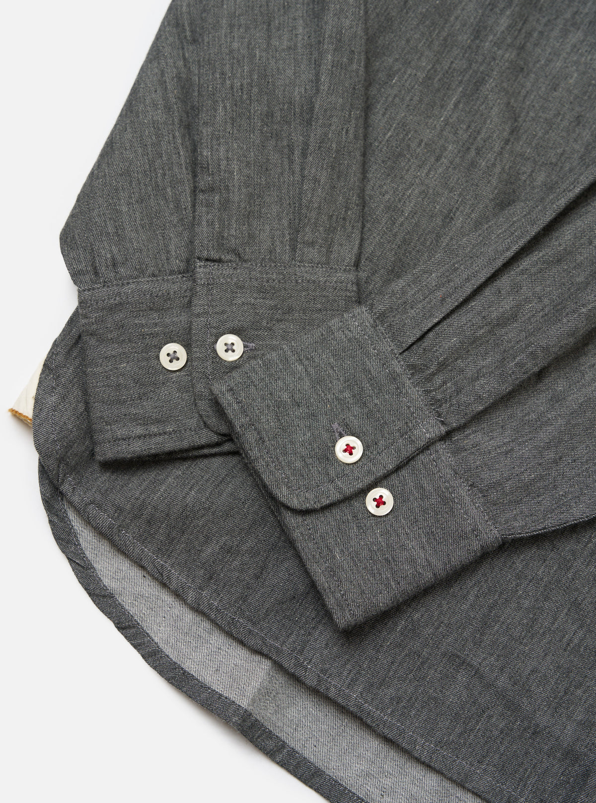 Close-up of the Charcoal Brushed Organic Cotton Square Pocket Shirt showing the cuff, buttons, and hem on a white background.