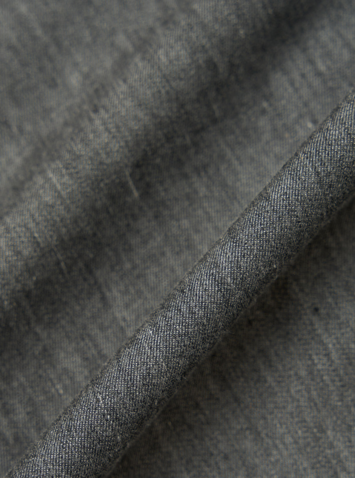 Close-up of the Charcoal Brushed Organic Cotton Square Pocket Shirt fabric. The charcoal material is folded to show texture.