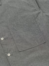 Close-up of the Charcoal Organic Chambray Lucky Shirt, showing the fabric texture, pocket, and buttons. The shirt is laid flat on a neutral surface.