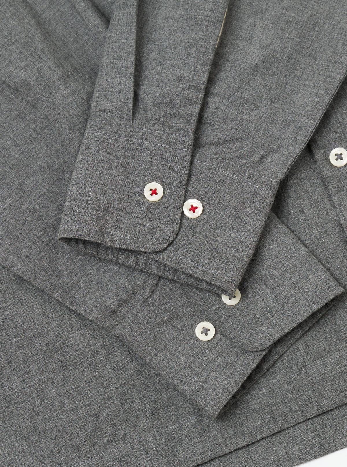 Close-up of the Charcoal Organic Chambray Lucky Shirt showing the fabric texture, button details, and sleeve cuffs on a plain background.
