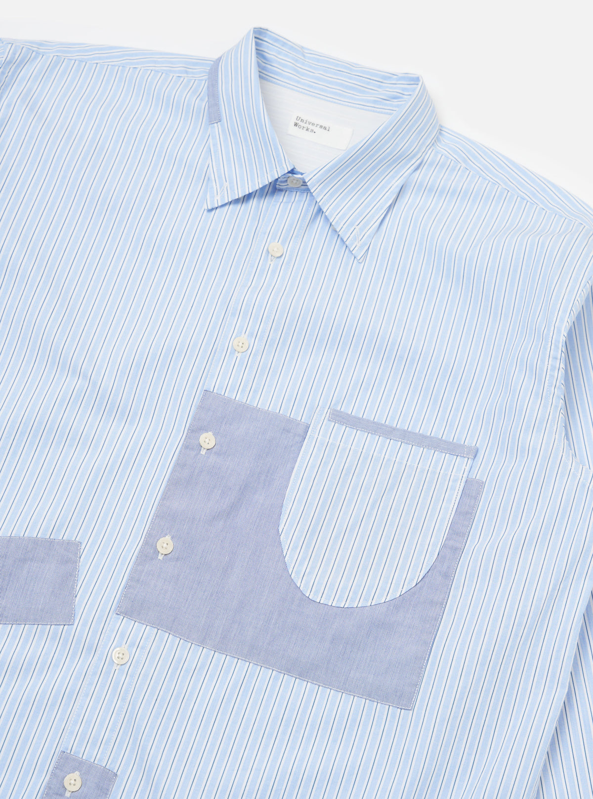 Close-up of the Blue Office Stripe Patched Lazy Day Shirt on a white background. The shirt features blue and white stripes with light blue patched pockets.