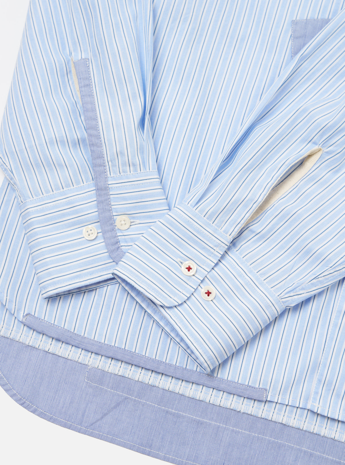 Close-up of the Blue Office Stripe Patched Lazy Day Shirt on a white surface. The shirt features light blue and white stripes, patched details, and buttoned cuffs.